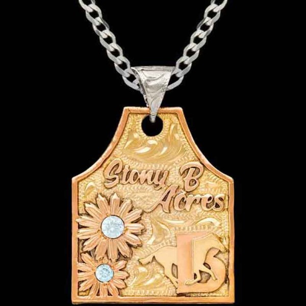 Embrace rustic elegance with our Buttercup Cow Tag Necklace, featuring a golden bronze base adorned with copper letters and two charming sunflowers.  Customize with your ranch logo!
